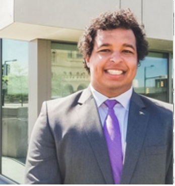 College of Business student, Maxwell Nixon. Standing outside in business attire.