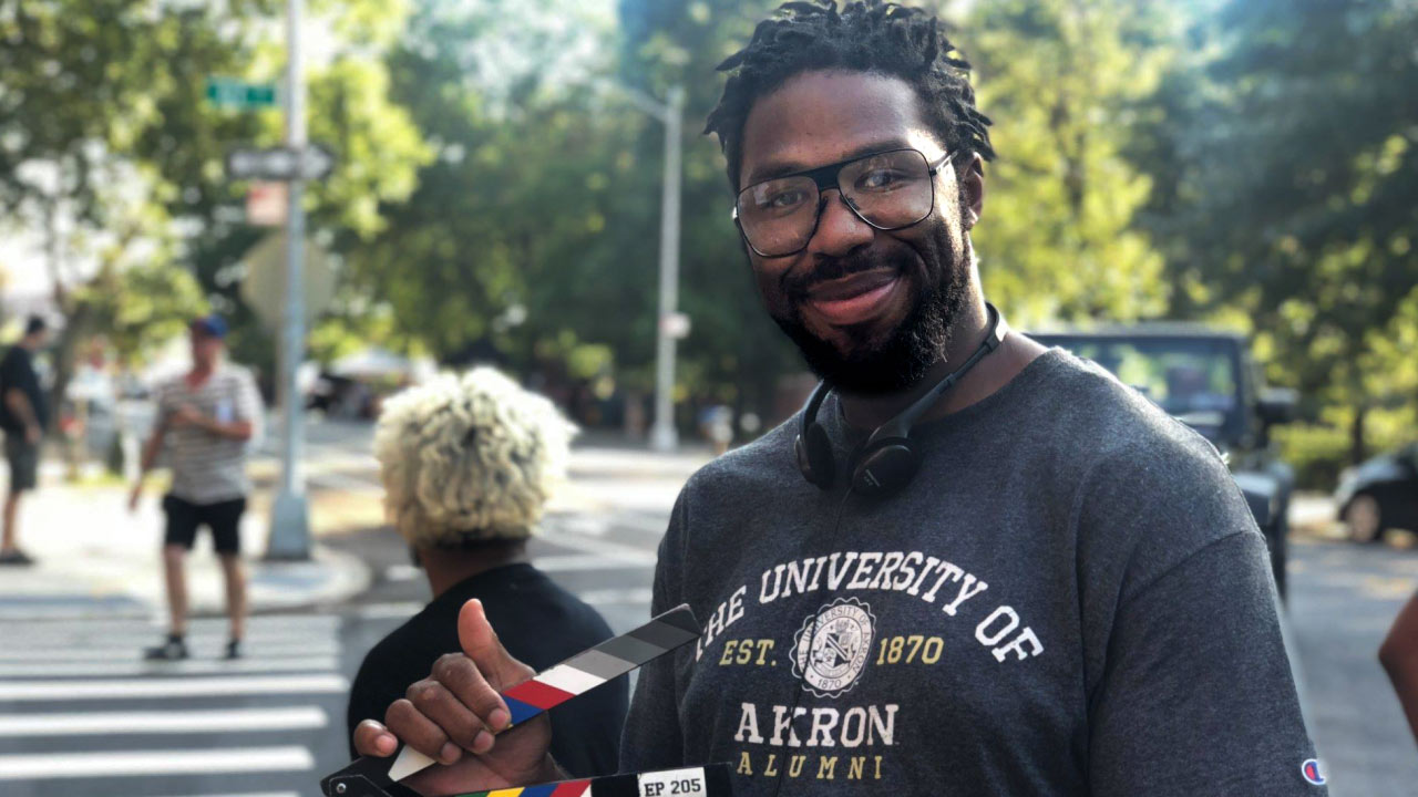 Matthew Cherry on a set wearing a UA T-shirt