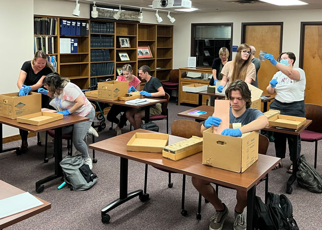 Graduate students sort through archival materials.