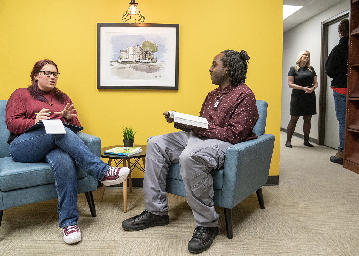 Two communication students work on a project in the library.